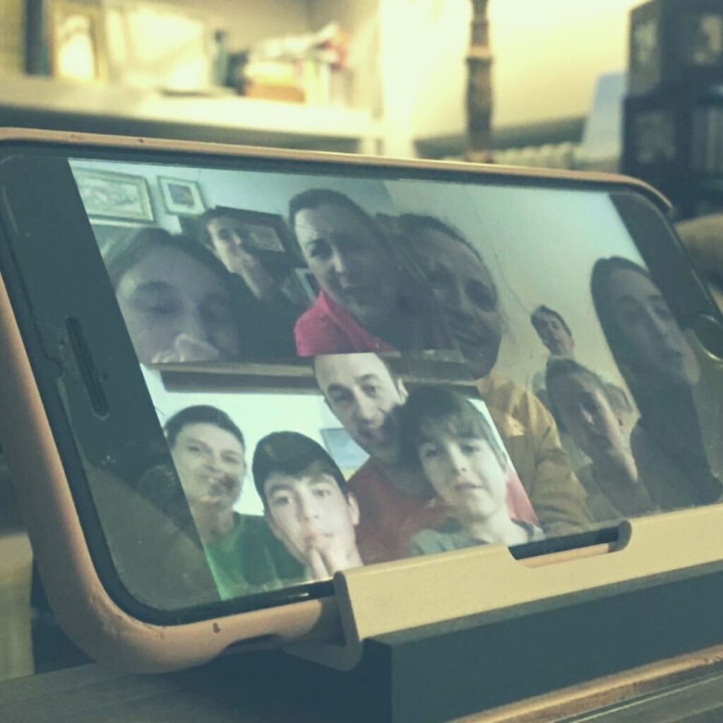 Imagen de un móvil donde se ve una videollamada de una familia
