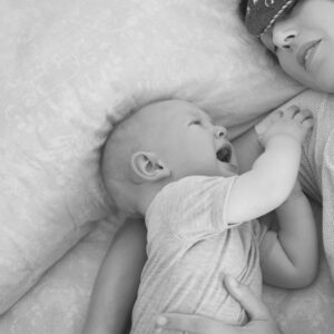 imagen en blanco y negro de bebé llorando junto a una madre agotada